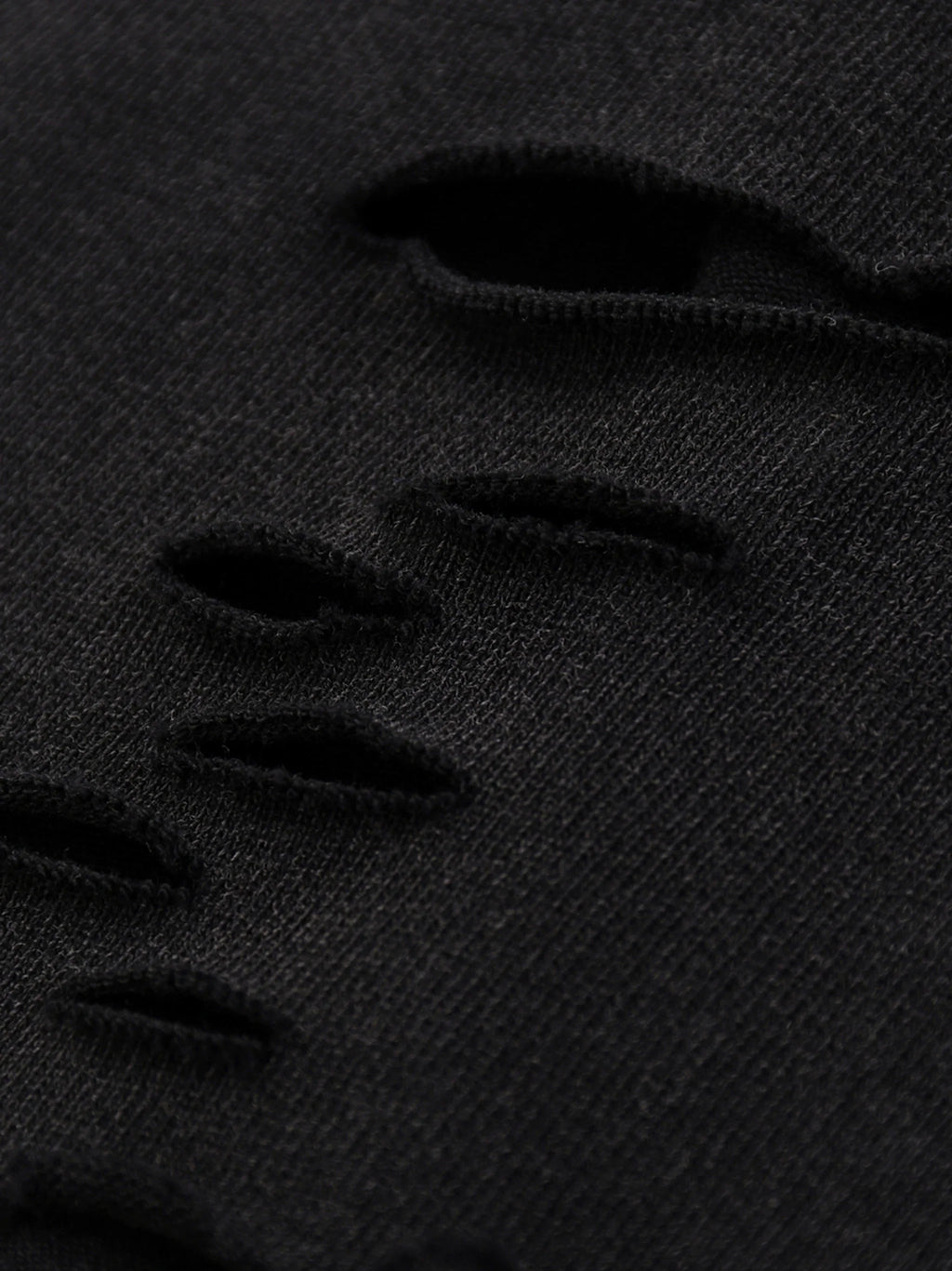 close-up of black distressed fabric with horizontal rips, urban streetwear style